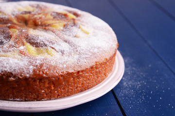Delicious cake with caramel on plate on wooden table