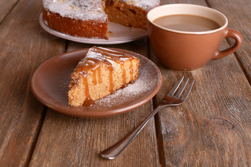 Delicious cake and cup of coffee on wooden table