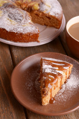 Delicious cake and cup of coffee on wooden table