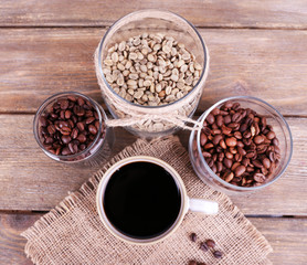 Obraz na płótnie Canvas Mug of coffee and jars of coffee beans