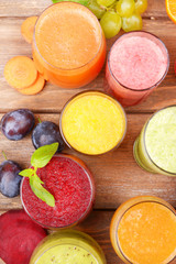 Obraz na płótnie Canvas Glasses of tasty fresh juice, on wooden table.