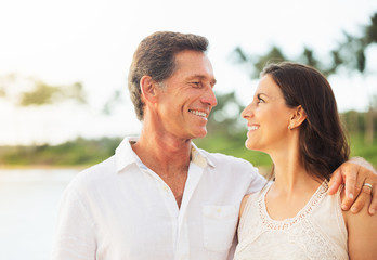 Obraz premium Mature Couple Enjoying Sunset on the Beach