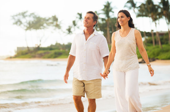 Mature Couple Enjoying Walk On The Beach