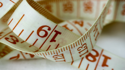 Red and white tailoring meter or tape measure. Close up.