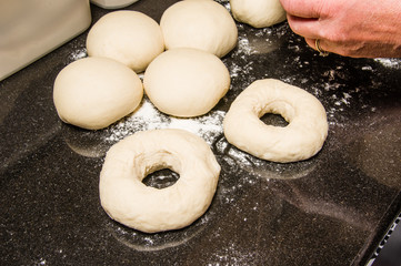 Baker forming bagels from dough