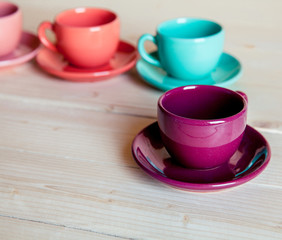 Fototapeta na wymiar Colorful coffee cups on wooden table