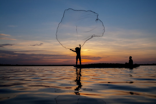 throwing fishing net during sunset.