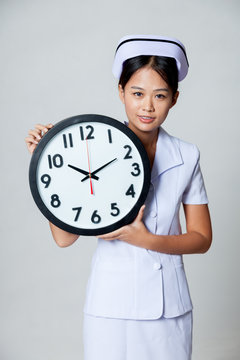 Asian young nurse with a clock