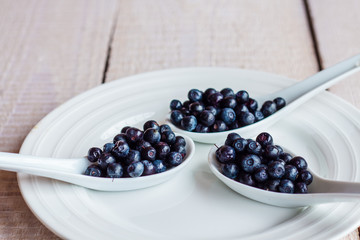 blueberries in the spoons on a white plate