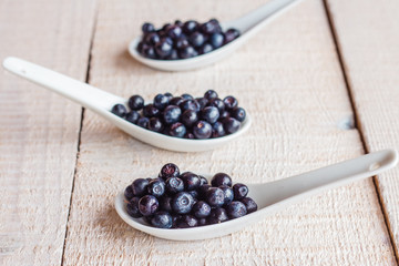 Blueberries in ceramic spoons, vertically
