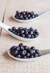 Blueberries in ceramic spoons, vertically