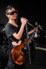 Young woman playing guitar during the concert