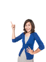 Woman smiling pointing up showing copy space.