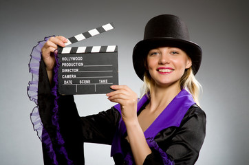 Woman with movie clapboard against grey background