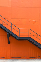 Metal fire escape or emergency exit on Orange Wall of Buliding