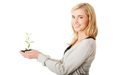 Woman with plant and dirt in hand