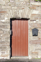 brown wooden doorway and a post box