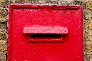 a traditional red post box in a wall.