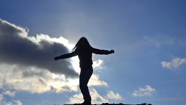 Silhouette of girl on the bright sky, Freedom concept
