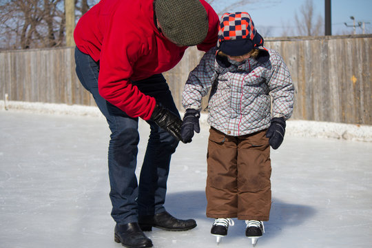 Father teaching son how to ice skate