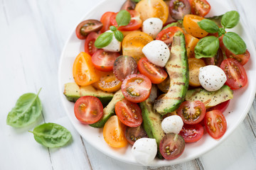 Salad with grilled avocado, tomatoes and mozzarella, close-up