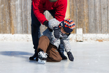 Father teaching son how to ice skate