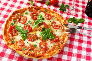Pizza Margherita mit Tomaten, Basilikum, Majoran und Mozzarella