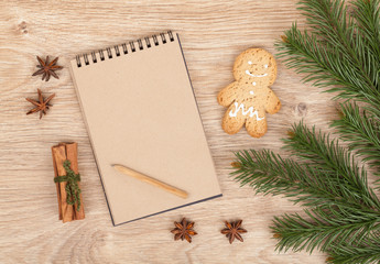 Obraz na płótnie Canvas Christmas fir tree, gingerbrean man and blank notepad