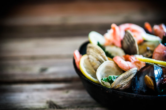 Mix of mussels,clams and shrimps on wooden background