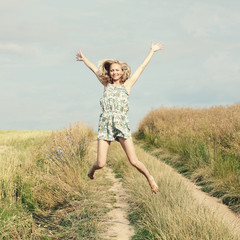 Fototapeta premium Happy Young Woman Jumping over blue sky. 