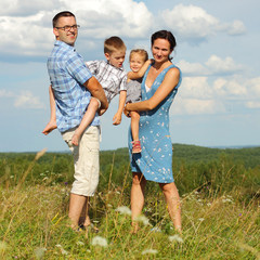 Family of four standing on a mountain 