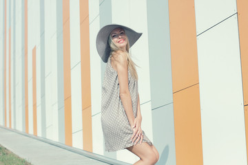 beautiful happy girl in a bright dress and a long hollow hat