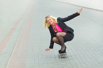 Senior business woman having fun on a skateboard outdoors