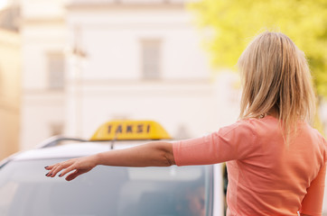 woman raising her arm to call a taxi