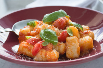Gnocchi with tomato sauce and basil leaves