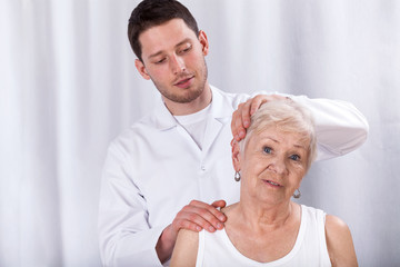 Physiotherapist helping patient with neck ache