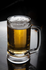 Mug of beer on black  table