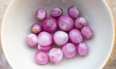 Sliced shallot with whole shallots on a cutting board