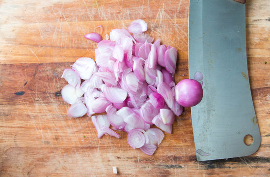 Sliced shallot with whole shallots on a cutting board
