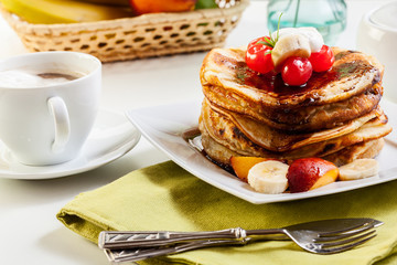 Pancakes with chocolate sauce fruit and coffee