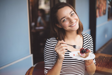 Young woman eating strawberry cheesecake