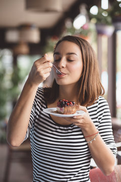 Young Woman Eating Strawberry Cheesecake