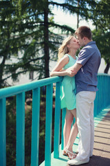 Fototapeta na wymiar Romantic happy couple in love kiss on the bridge