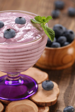 yogurt with blueberries in a glass bowl and blueberries in a gla