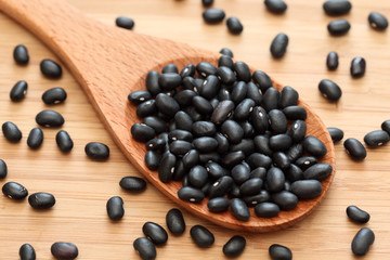 Black beans in a wooden spoon