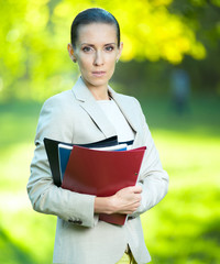 Fototapeta premium Portrait of smiling business woman with paper folder. Student