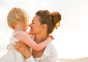 Portrait of mother and baby girl hugging on the beach 