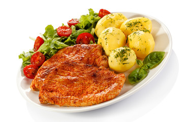 Fried pork chop, boiled potatoes and vegetable salad