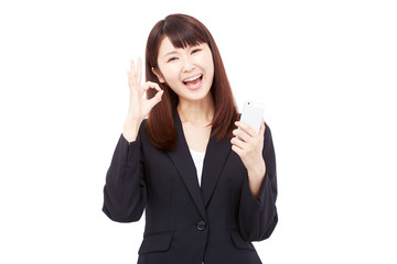 スマートフォンを持ってOKサインするビジネスウーマン