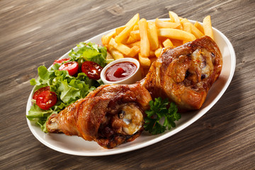 Grilled turkey legs with French fries and vegetables